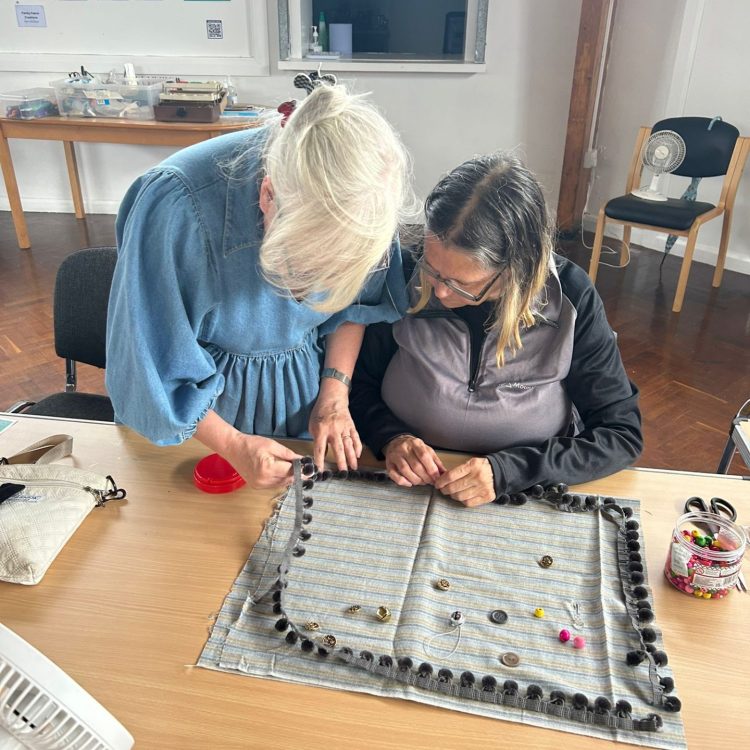 Sunderland Mind Volunteer helping Fabric Creations member create a sensory mat for people with dementia