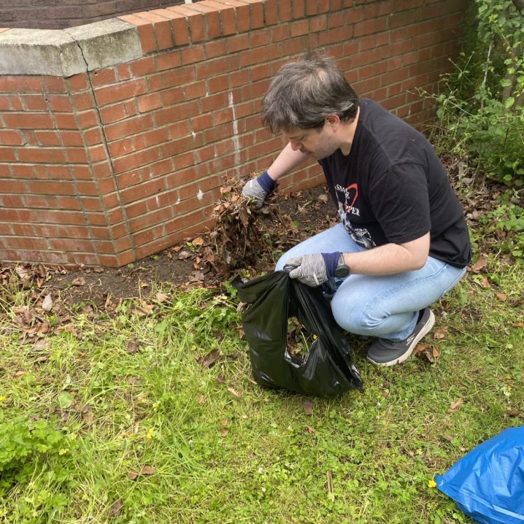 Wellbeing Wednesday member gardening + picking up leaves